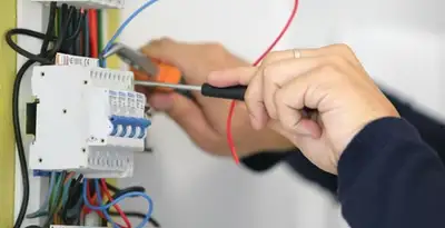 Electrician installing and adjusting circuit breakers in an electrical panel in Aurora, CO