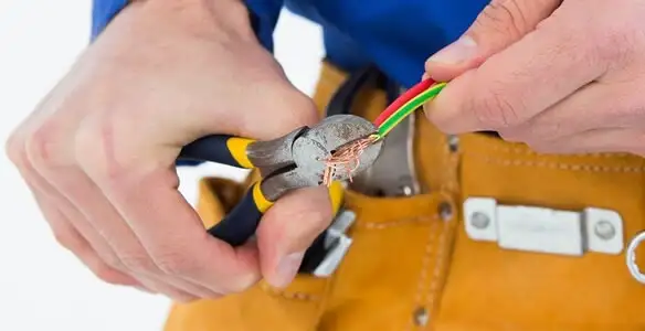licensed electrician securing electrical wiring with professional tools during service work in Aurora, CO