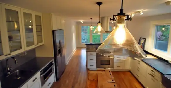 Residential electrician installing modern indoor light fixture in a home in Aurora, CO